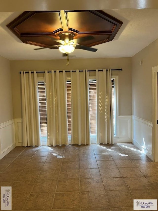901 Morelos Ave, Rancho Viejo, TX 78575 - spare room with wainscoting, a decorative wall, ceiling fan, and tile patterned flooring