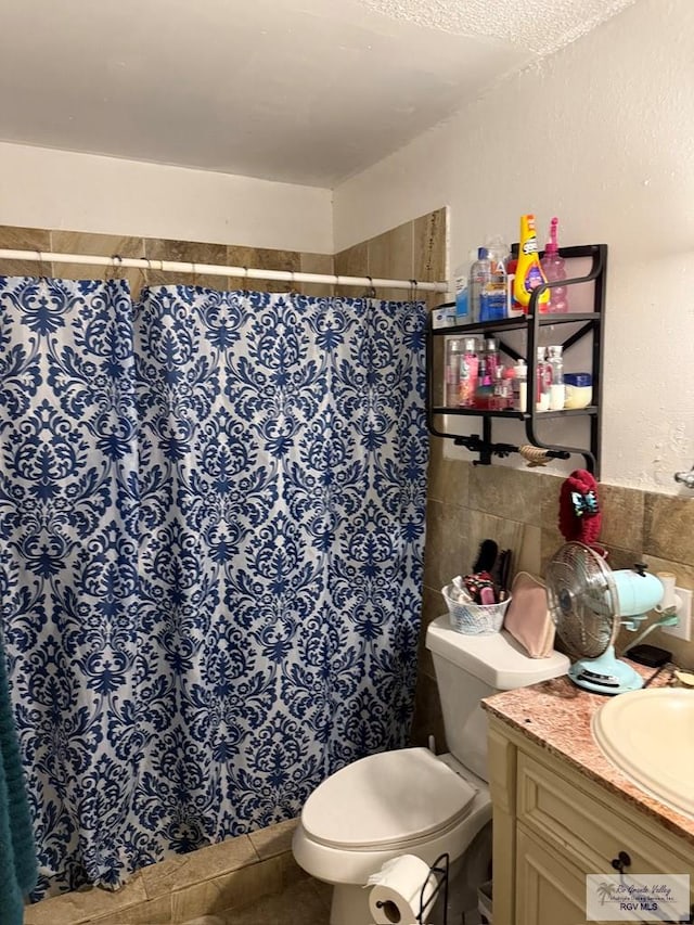 bathroom with a shower with curtain, tile walls, toilet, and vanity