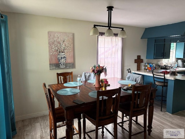 dining area with light wood finished floors and baseboards