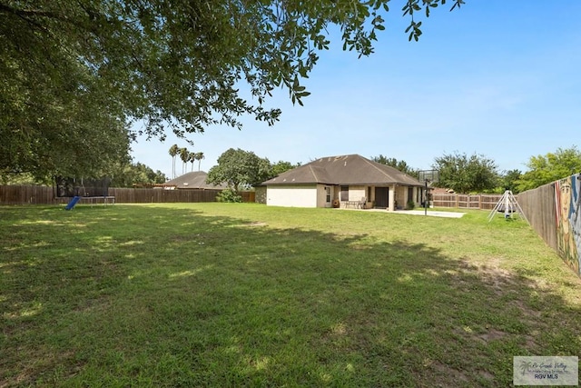313 Scarlett Cir, Harlingen, TX 78552 - fenced backyard featuring a trampoline and a patio