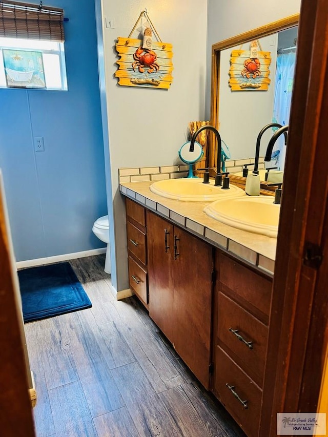 bathroom with vanity, hardwood / wood-style flooring, and toilet