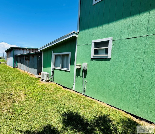 view of side of property featuring ac unit and a lawn