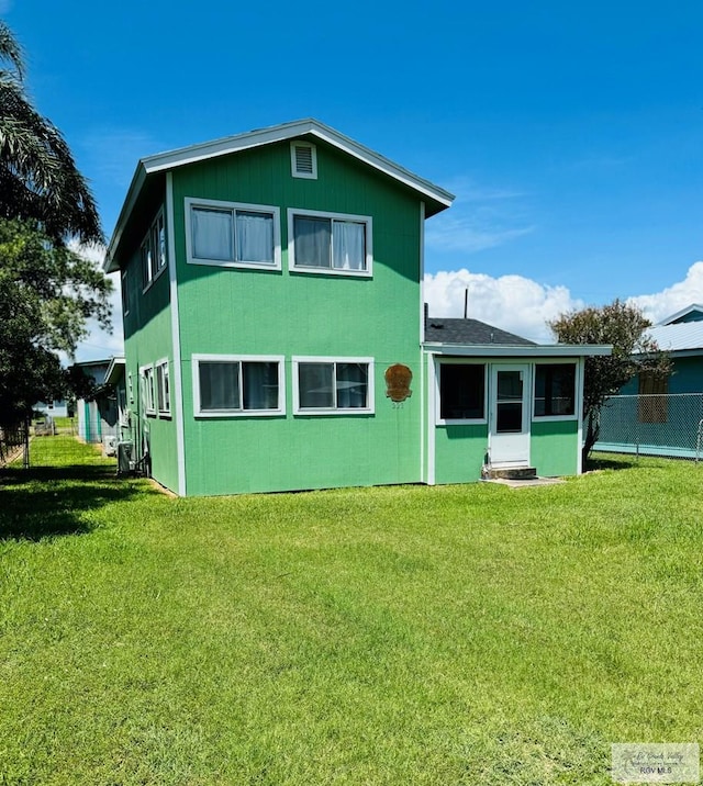 rear view of property with a lawn