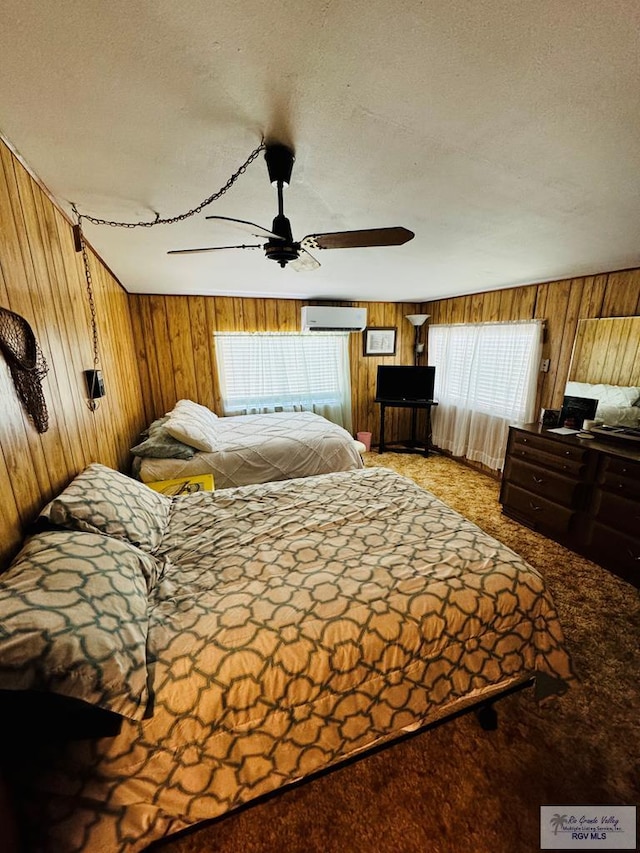 carpeted bedroom featuring a wall mounted AC, wood walls, and a textured ceiling