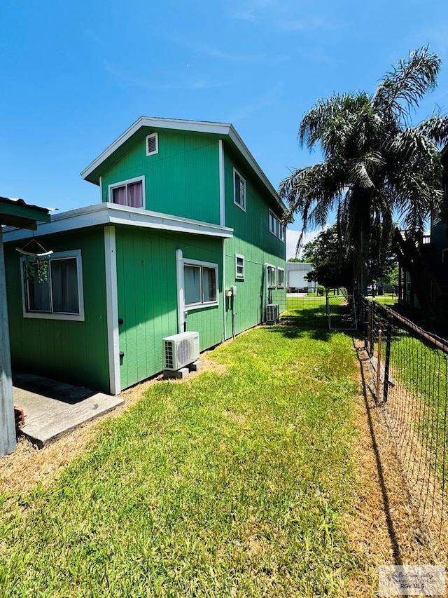 exterior space featuring a yard and central AC