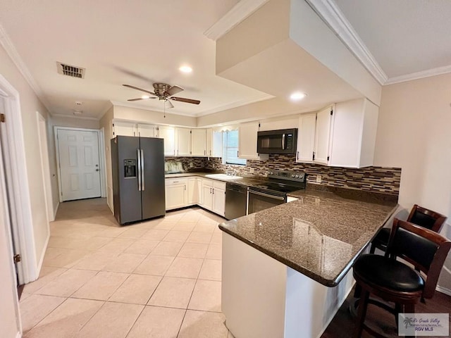 40 Cherokee Ave, Harlingen, TX 78552 - kitchen with black appliances, a peninsula, crown molding, decorative backsplash, and dark stone counters