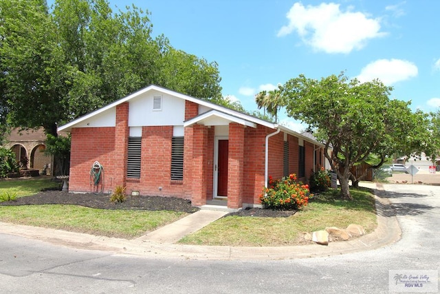 40 Cherokee Ave, Harlingen, TX 78552 - view of front facade with brick siding and a front yard