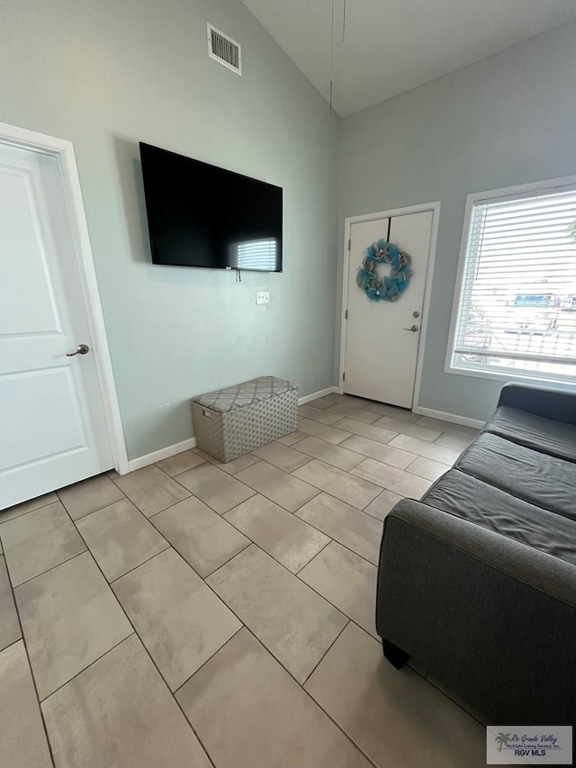 living room featuring light tile patterned flooring and vaulted ceiling