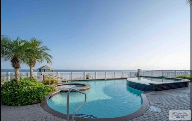 view of swimming pool featuring a water view and a community hot tub