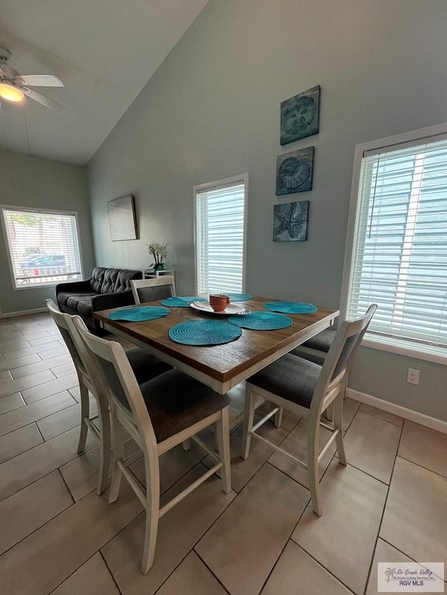 tiled dining room featuring high vaulted ceiling and ceiling fan