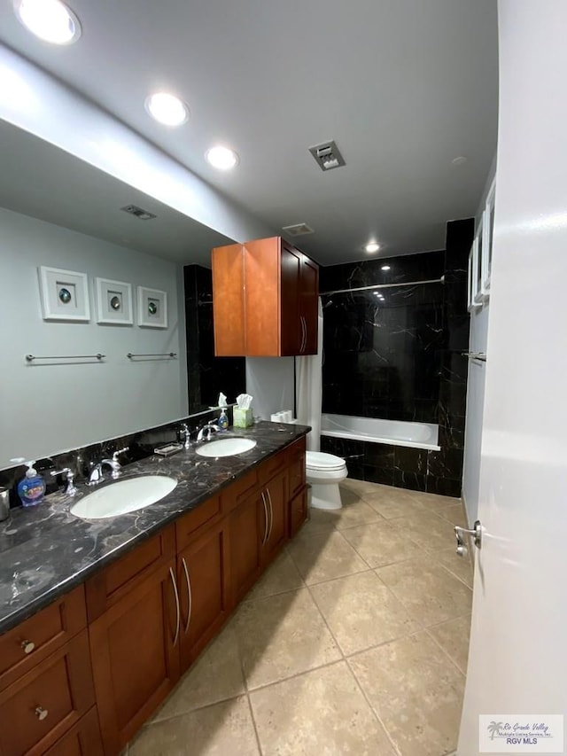 full bathroom featuring vanity, toilet, tiled shower / bath combo, and tile patterned flooring