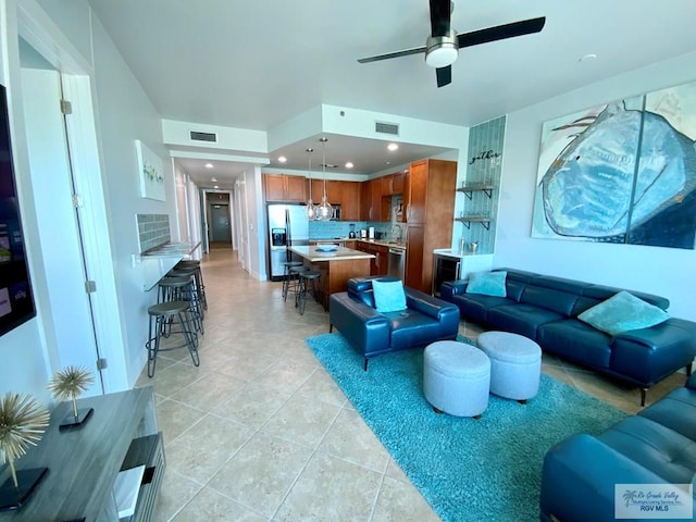 tiled living room with ceiling fan