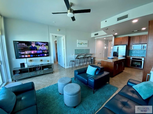 living room with ceiling fan and light tile patterned floors