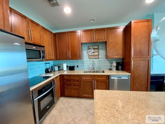 kitchen with light tile patterned flooring, stainless steel appliances, sink, and decorative backsplash