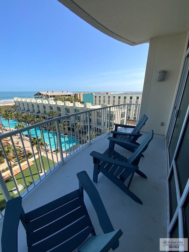 balcony with a water view and a beach view