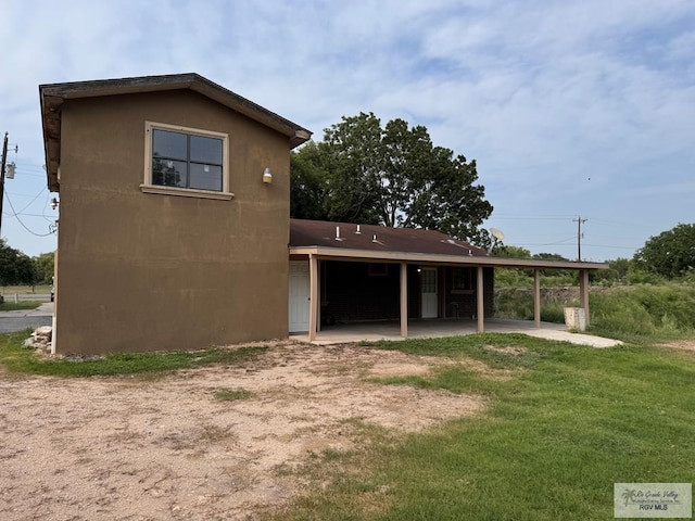 back of property with a lawn and a patio