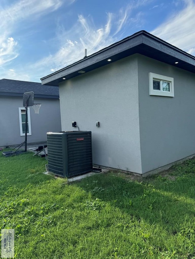 view of home's exterior with central air condition unit and a lawn