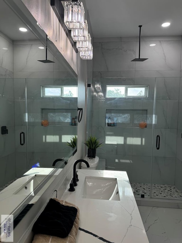 bathroom with vanity, an enclosed shower, and an inviting chandelier