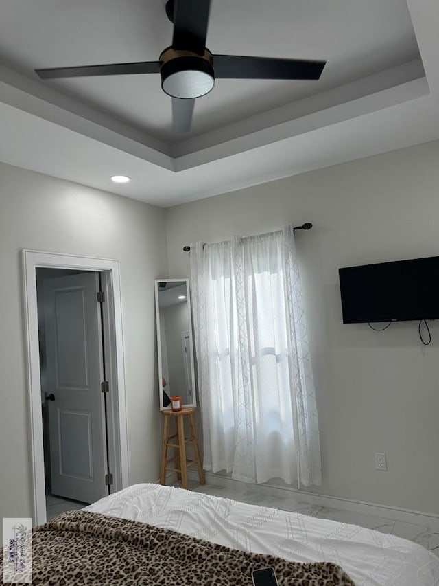 unfurnished bedroom featuring ceiling fan and a raised ceiling