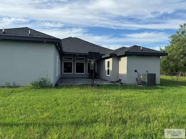 rear view of house with a yard, a patio, and central AC