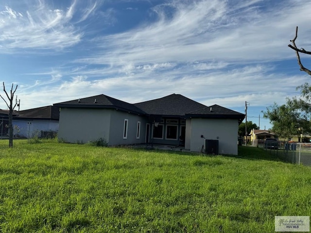 back of house with a lawn and cooling unit