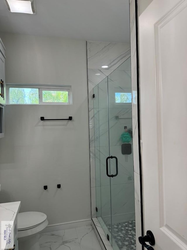 bathroom with vanity, toilet, and a shower with door