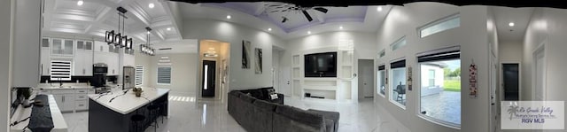 kitchen featuring white cabinetry, coffered ceiling, ceiling fan, and a high ceiling