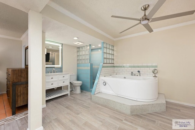 1302 Harbor Island Dr, Port Isabel, TX 78526 - full bathroom featuring a textured ceiling, crown molding, vanity, wood finished floors, and a garden tub