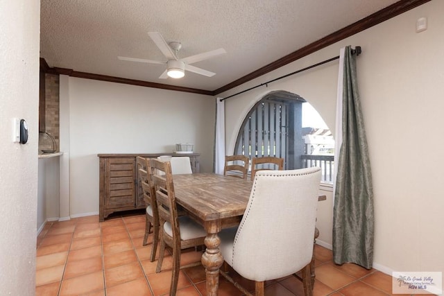 1302 Harbor Island Dr, Port Isabel, TX 78526 - dining space with crown molding, a textured ceiling, a ceiling fan, arched walkways, and light tile patterned flooring