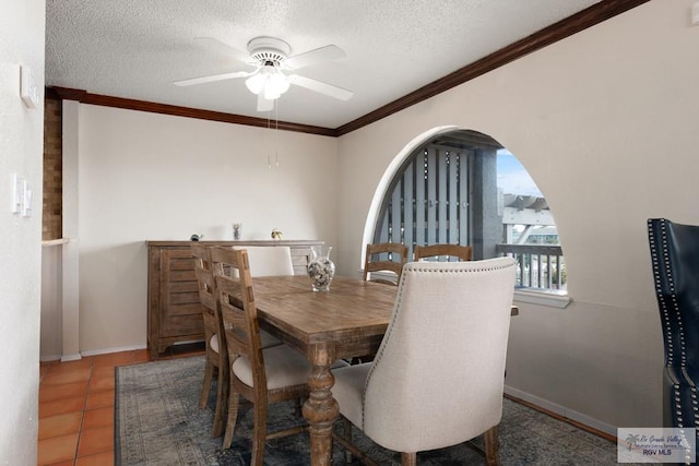 1302 Harbor Island Dr, Port Isabel, TX 78526 - tiled dining room with a ceiling fan, ornamental molding, a textured ceiling, and arched walkways