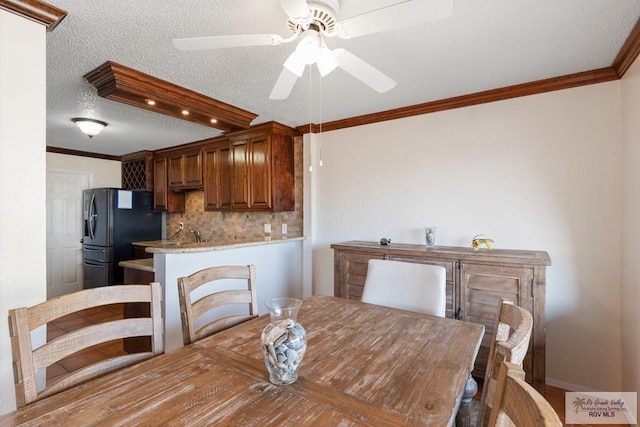 1302 Harbor Island Dr, Port Isabel, TX 78526 - dining area featuring a ceiling fan, ornamental molding, and a textured ceiling