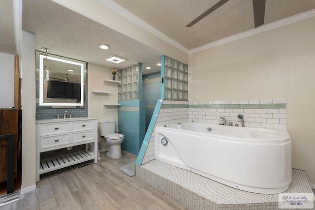 1302 Harbor Island Dr, Port Isabel, TX 78526 - full bath featuring tile walls, wood finished floors, a garden tub, vanity, and crown molding