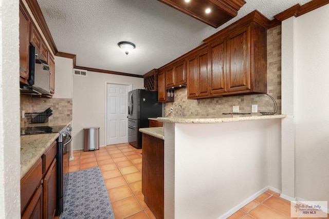 1302 Harbor Island Dr, Port Isabel, TX 78526 - kitchen with stainless steel appliances, tasteful backsplash, crown molding, light tile patterned floors, and a peninsula