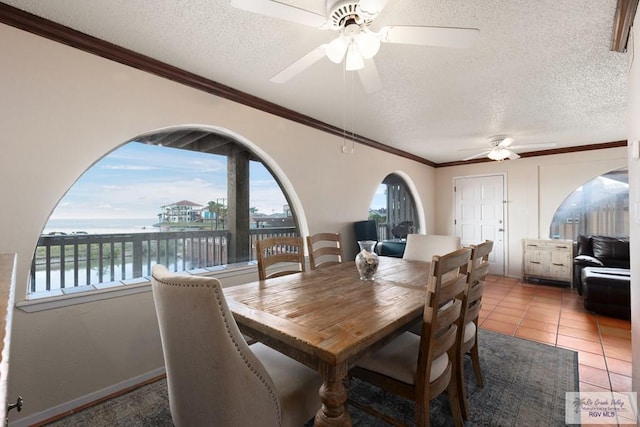 1302 Harbor Island Dr, Port Isabel, TX 78526 - dining room with ceiling fan, plenty of natural light, a water view, a textured ceiling, and crown molding