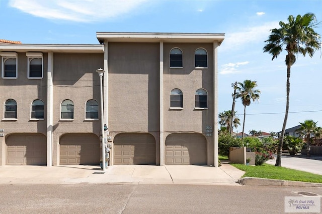 1302 Harbor Island Dr, Port Isabel, TX 78526 - view of front facade featuring a garage, driveway, and stucco siding