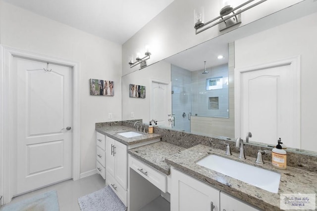 full bath with a shower stall, vanity, and baseboards