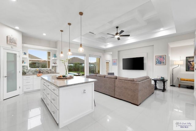 living room featuring recessed lighting, a raised ceiling, and ceiling fan