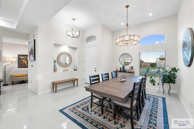 dining space with recessed lighting, baseboards, a high ceiling, and a chandelier