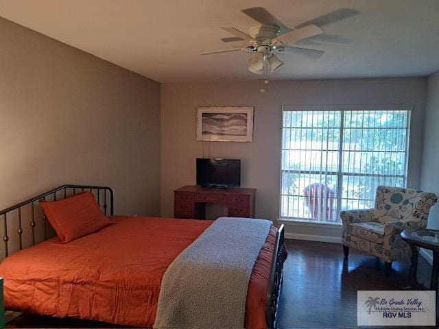 bedroom with dark hardwood / wood-style flooring and ceiling fan