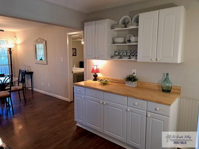 kitchen with crown molding, white cabinets, dark hardwood / wood-style floors, and wood counters