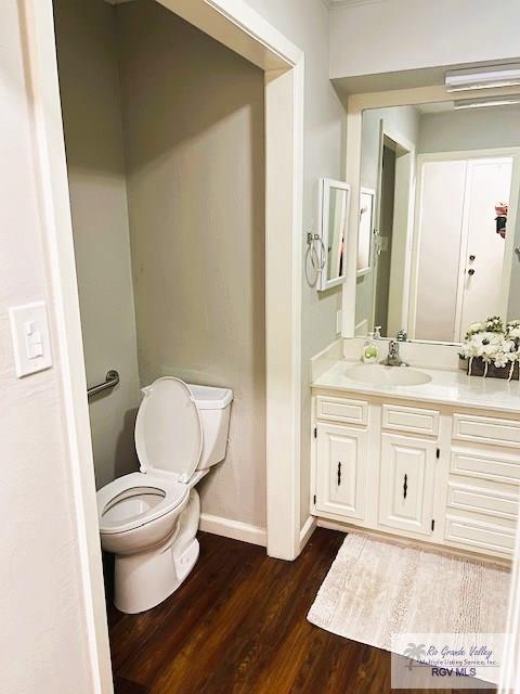 bathroom with vanity, hardwood / wood-style flooring, and toilet