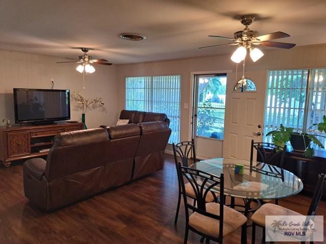 living room featuring ceiling fan and dark wood-type flooring