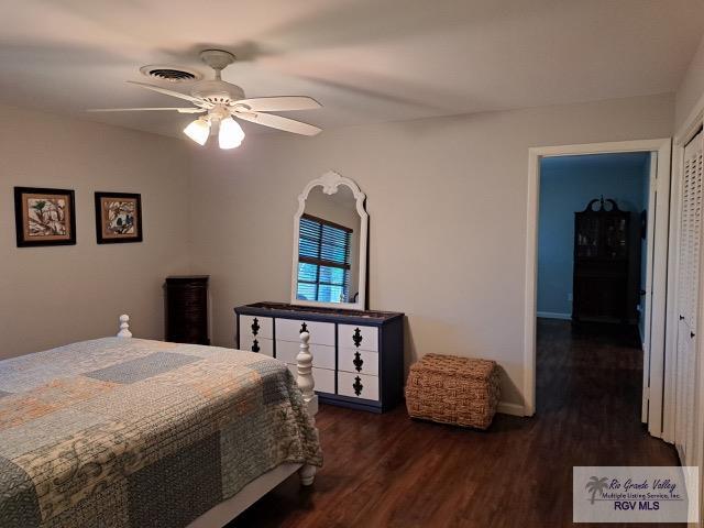 bedroom featuring ceiling fan, dark hardwood / wood-style floors, and a closet