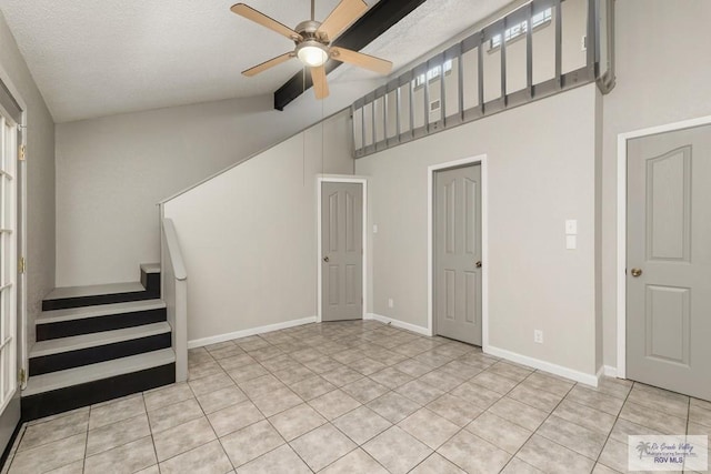 interior space with light tile patterned floors, a textured ceiling, ceiling fan, and lofted ceiling