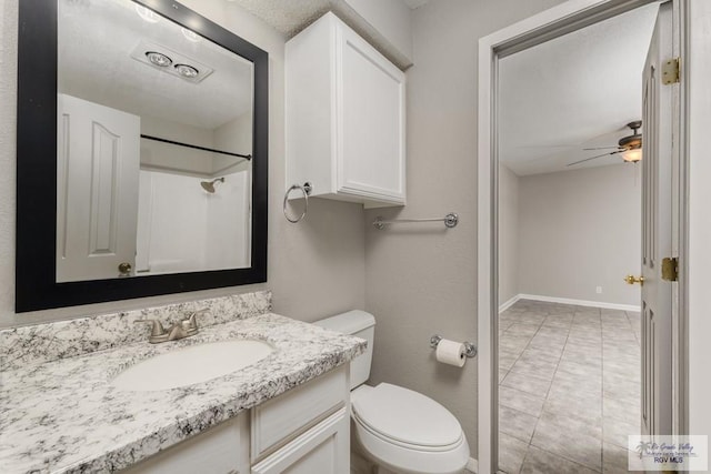 bathroom with vanity, ceiling fan, toilet, and a shower