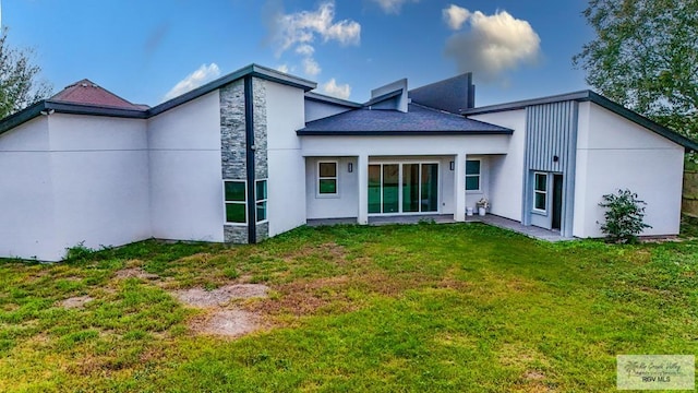 rear view of property featuring a lawn