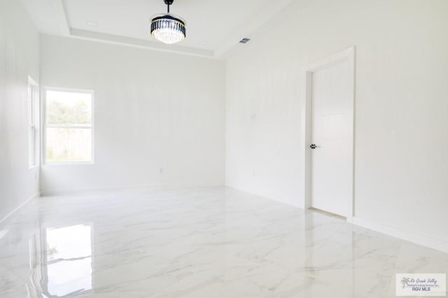 unfurnished room featuring a tray ceiling