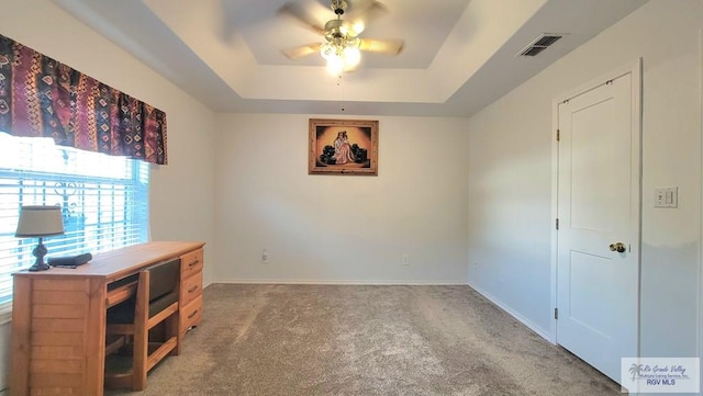 unfurnished room with carpet, a tray ceiling, and ceiling fan