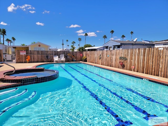 view of pool with a hot tub