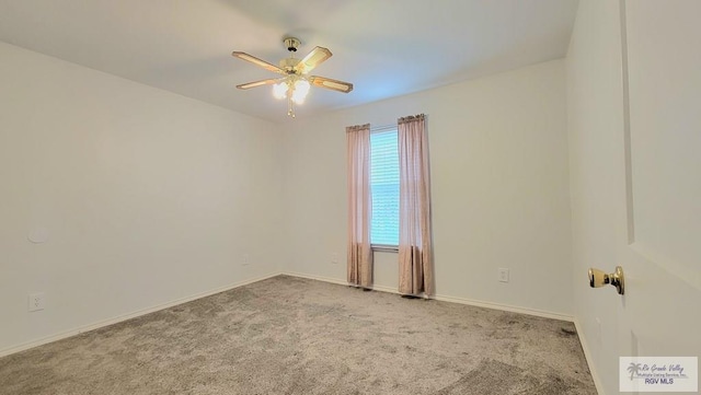 carpeted spare room featuring ceiling fan